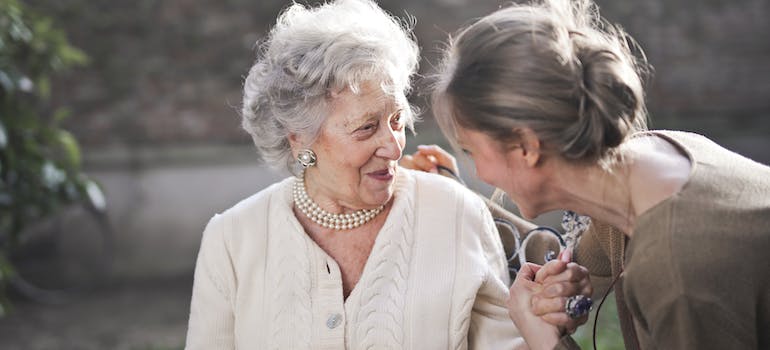 younger woman helping her elderly client who is moving to Dulles.