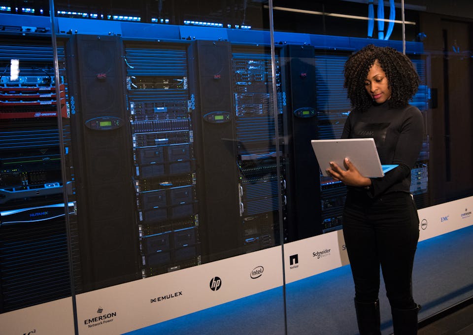 Data migration company expert holding a laptop in front of servers