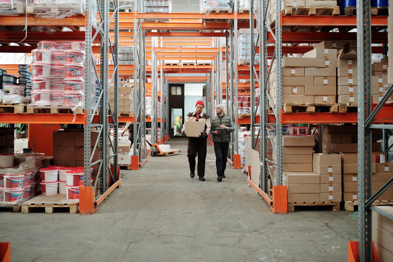 The workers walk along the warehouse.