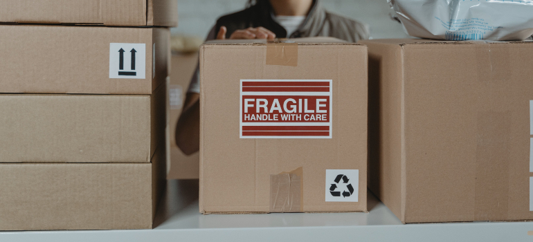 Person handling a box containing fragile healthcare equipment representing Critical Equipment Handling: Best Practices for Healthcare Relocation
