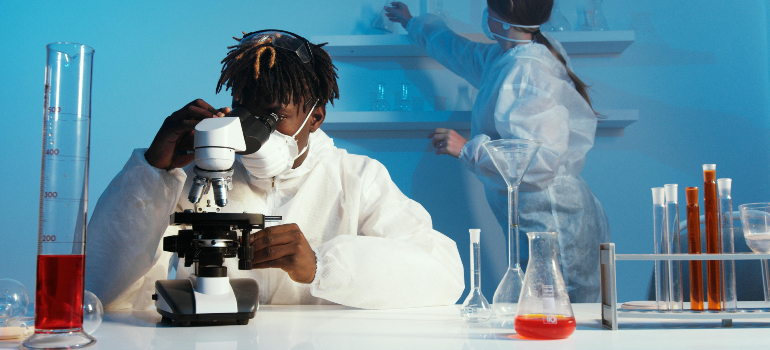 two people doing an experiment with a microscope