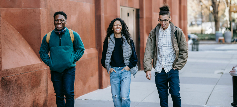 three friends walking together talking about staying safe in a new country