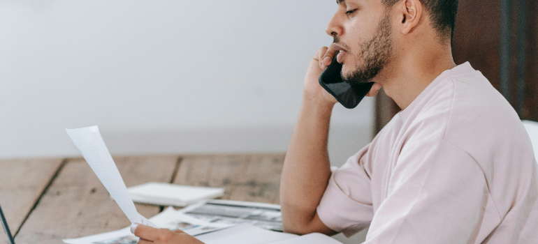 a man talking on the phone about how to reuse and recycle office furniture during a move