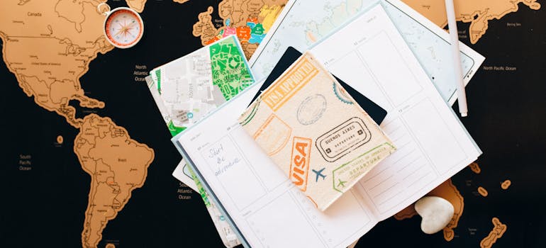 visa, passport, and papers placed on a map of the world