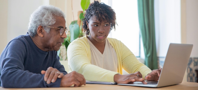 A Man and a Woman using a Laptop Together to read about the Tips for Helping Your Senior Loved One Move