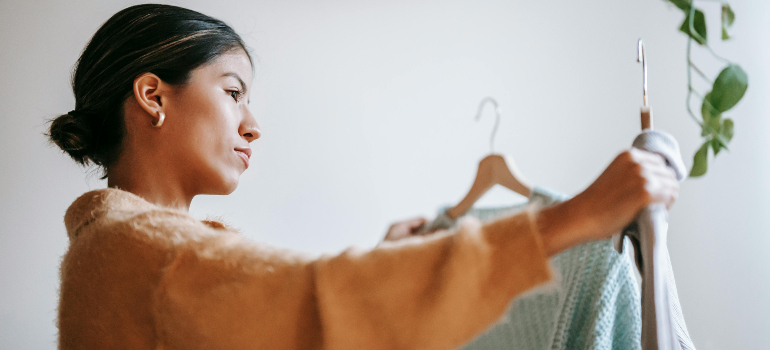 woman organizing clothes using tips on handling student belongings and inventory during housing moves