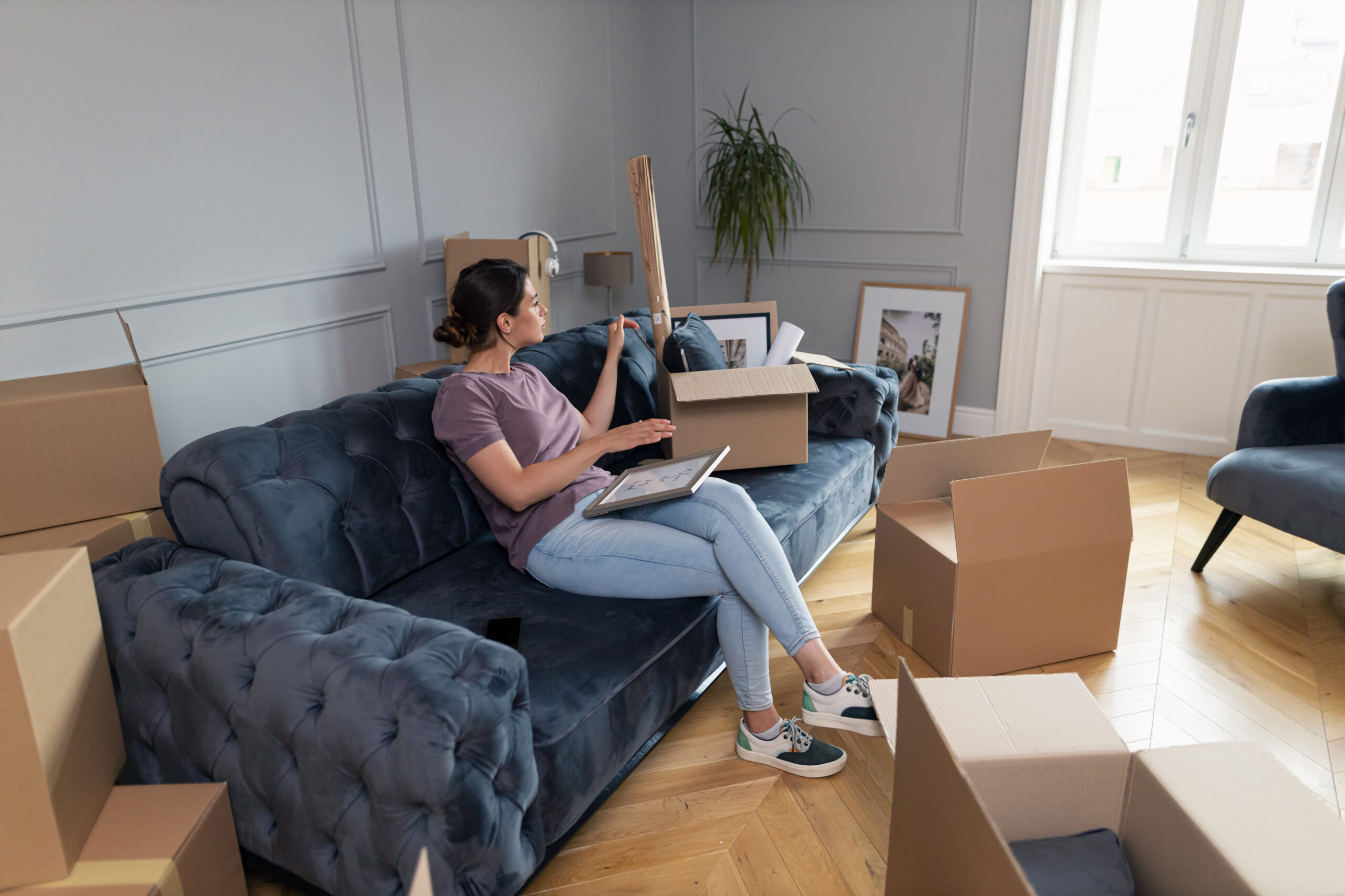 Lading sitting on couch moving furniture