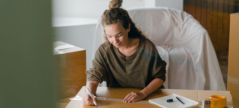 a woman labeling a box 