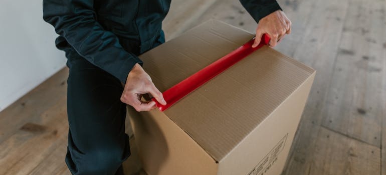a mover taping a box