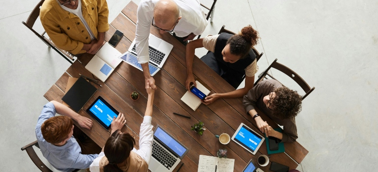 Healthcare professionals are sitting around the table and talking about the role of technology in streamlining healthcare facility relocations.