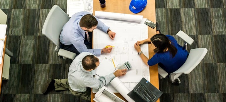people at a table creating a plan to manage construction delays in educational institution renovations 
