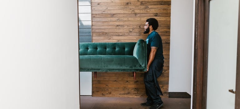 Mover carrying a green couch moving to a historic DC area home