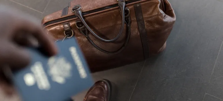 Man holding a passport and travel bag 