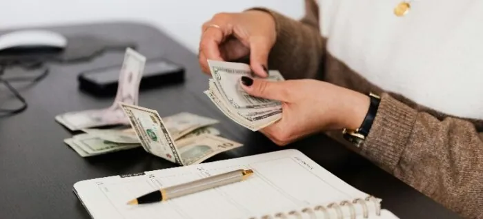 a person counting money after learning about the cost of living in Sterling