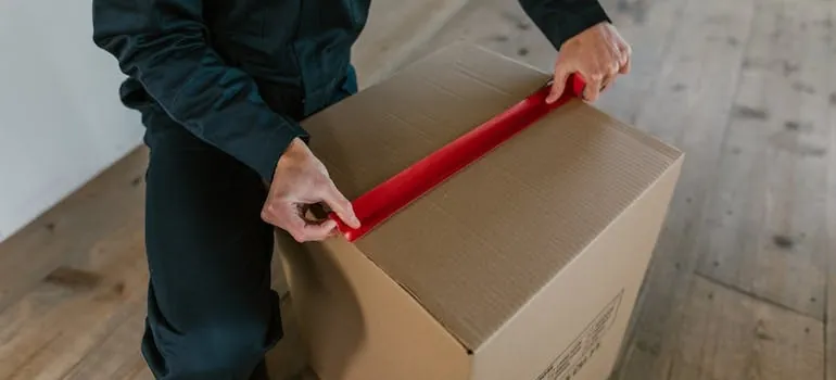 a mover taping a box